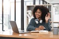 Smiling young african american teen girl wear headphones video calling on laptop. Happy woman student looking at Royalty Free Stock Photo