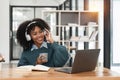 Smiling young african american teen girl wear headphones video calling on laptop. Happy woman student looking at Royalty Free Stock Photo