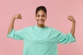 Smiling young african american woman girl in green sweatshirt posing isolated on pastel pink background studio portrait Royalty Free Stock Photo