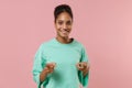 Smiling young african american woman girl in green sweatshirt posing isolated on pastel pink background studio portrait Royalty Free Stock Photo