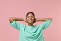 Smiling young african american woman girl in green sweatshirt posing isolated on pastel pink wall background. People Royalty Free Stock Photo