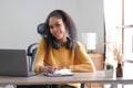 Smiling young African American woman in headphones distracted from computer work look in distance dreaming. Happy biracial female Royalty Free Stock Photo