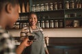 Smiling young African barista giving her customer a cappuccino Royalty Free Stock Photo