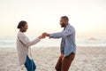 Smiling young African couple dancing on a beach at sunset