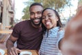 Smiling young African couple taking selfies together at a cafe Royalty Free Stock Photo