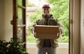 Smiling African delivery man holding packages at a front door Royalty Free Stock Photo