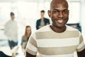 Smiling young African designer standing in a modern office Royalty Free Stock Photo