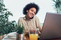 Young African female entrepreneur sitting at a desk in her home office working online with a laptop Royalty Free Stock Photo