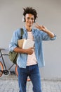 Smiling young african man with backpack outdoors Royalty Free Stock Photo