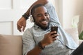 Smiling young african man wearing headphones listen to mobile music
