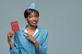 Smiling young african stewardess holding passport in her hand. Royalty Free Stock Photo