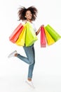 Smiling young african woman jumping shopping bags. Royalty Free Stock Photo