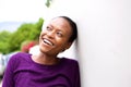 Smiling young african woman leaning against wall Royalty Free Stock Photo