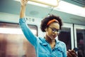 Smiling young African woman listening to music on the subway Royalty Free Stock Photo