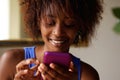 Smiling young african woman looking at cell phone Royalty Free Stock Photo