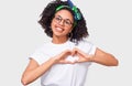 Smiling young African woman making heart shape with fingers. Beautiful Afro female dressed in white t-shirt and eyeglasses,