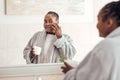 Young African woman applying face cream in the bathroom Royalty Free Stock Photo