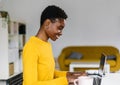 Smiling young african woman working on laptop computer from home office Royalty Free Stock Photo