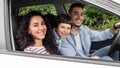 Smiling young arab man and woman with child are driving in car and looking at camera from open window Royalty Free Stock Photo