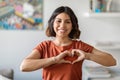 Smiling Young Arab Woman Showing Heart Gesture With Hands Near Chest Royalty Free Stock Photo