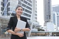 Smiling young Asian business woman with laptop at outside office Royalty Free Stock Photo