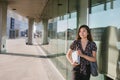 Young Asian university student standing on campus carrying textbooks Royalty Free Stock Photo