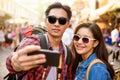 Smiling young Asian couple tourists taking selfie