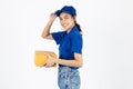 Smiling young Asian delivery woman in blue uniform holding package parcel box over white isolated background Royalty Free Stock Photo