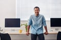 Smiling young Asian designer standing in a modern office Royalty Free Stock Photo
