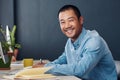 Smiling young Asian entrepreneur working at his office desk Royalty Free Stock Photo