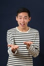 Smiling young Asian man gesturing with two hands Royalty Free Stock Photo