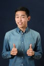 Smiling young Asian man giving the thumbs up signs