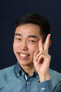 Smiling young Asian man giving victory sign Royalty Free Stock Photo