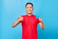 Smiling young asian man holding credit card and showing thumb up gesture on blue background Royalty Free Stock Photo