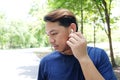 Smiling Young Asian man in sportwear is running or jogging and listening to music with white headphones. Royalty Free Stock Photo