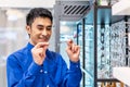 Smiling young asian man trying on new eyeglasses in the optical shop. Handsome man wearing new spectacles Royalty Free Stock Photo