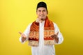 Smiling Young Asian Muslim man with welcome gesture during Ramadan Royalty Free Stock Photo