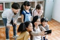 Smiling young Asian teacher making selfie with her schoolchildren in classroom. Elementary school,technology, children and people