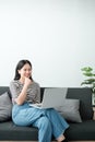 Smiling young asian teen girl video calling on laptop. Happy mixed race pretty woman student looking at computer screen Royalty Free Stock Photo