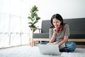 Smiling young asian teen girl video calling on laptop. Happy mixed race pretty woman student looking at computer screen Royalty Free Stock Photo