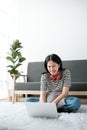 Smiling young asian teen girl video calling on laptop. Happy mixed race pretty woman student looking at computer screen Royalty Free Stock Photo