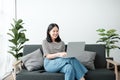 Smiling young asian teen girl video calling on laptop. Happy mixed race pretty woman student looking at computer screen Royalty Free Stock Photo