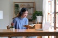 Smiling young asian teen girl wear headphones video calling on laptop. Happy pretty woman student looking at computer screen Royalty Free Stock Photo