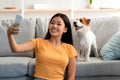 Smiling young asian woman taking selfie with her cute dog Royalty Free Stock Photo