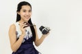 Smiling Young Asian woman cleaning DSLR camera with a blower. In the white room at the studio. Concept clean camera photography