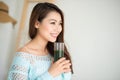 Smiling young asian woman drinking green fresh vegetable juice o Royalty Free Stock Photo