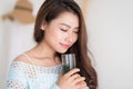 Smiling young asian woman drinking green fresh vegetable juice o Royalty Free Stock Photo