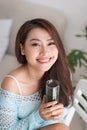 Smiling young asian woman drinking green fresh vegetable juice o Royalty Free Stock Photo