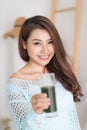 Smiling young asian woman drinking green fresh vegetable juice o Royalty Free Stock Photo