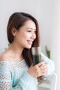 Smiling young asian woman drinking green fresh vegetable juice o Royalty Free Stock Photo